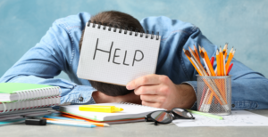 Un homme est effondré sur son bureau. Il demande de l'aide