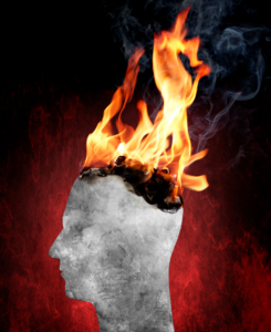Une tête de profil est en train de brûler, symbolisant le burn-out