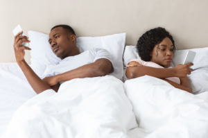 Deux partenaires sont chacun sur leur téléphone. Dans le lit, ils sont seuls, à deux. Ils ne se parlent pas, ne se voient pas.